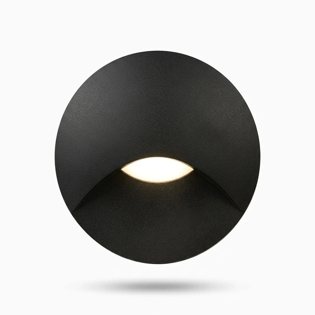 Lampe applique ronde étanche installée sur marche d'escalier intérieur, diffusion lumineuse basse sans éblouissement