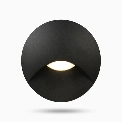 Lampe applique ronde étanche installée sur marche d'escalier intérieur, diffusion lumineuse basse sans éblouissement