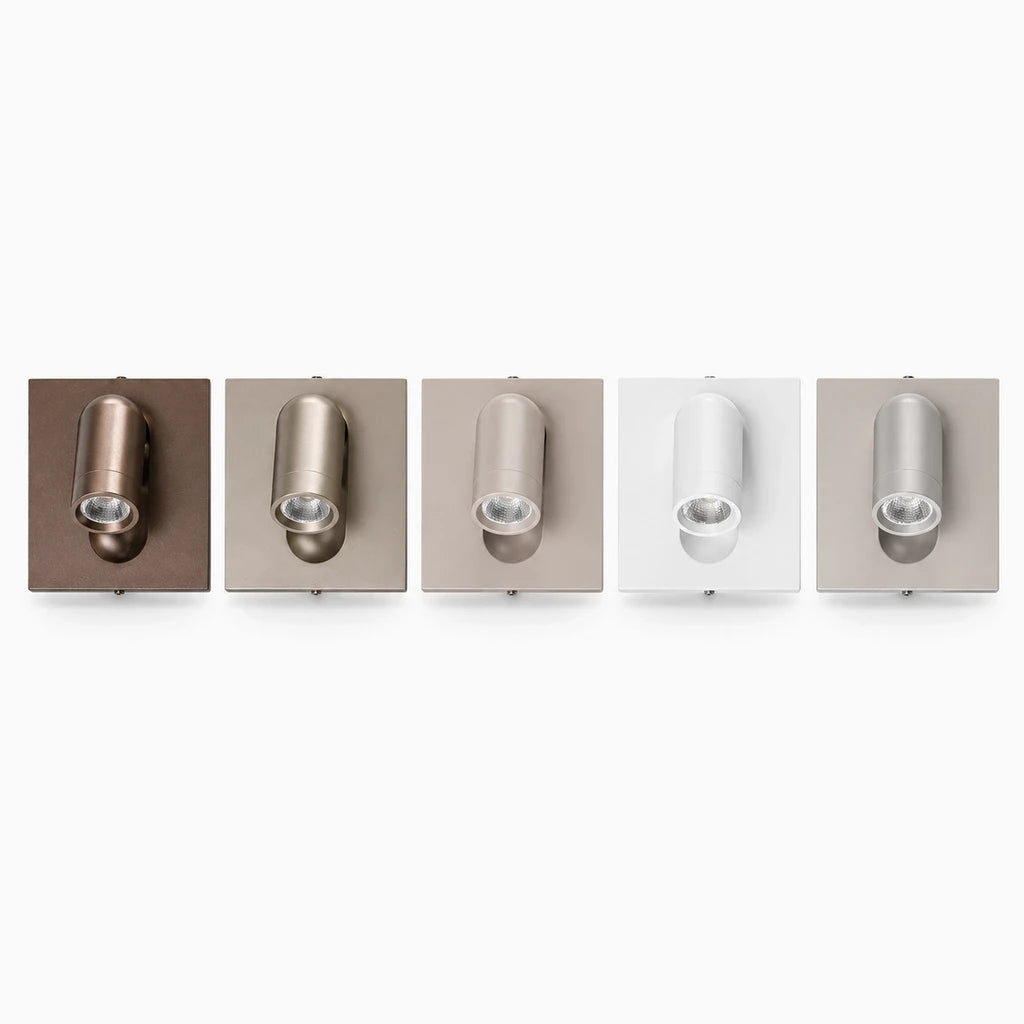 Luminaire de chevet blanc mat avec articulation flexible et interrupteur intégré, fixé à la paroi près de la tête de lit