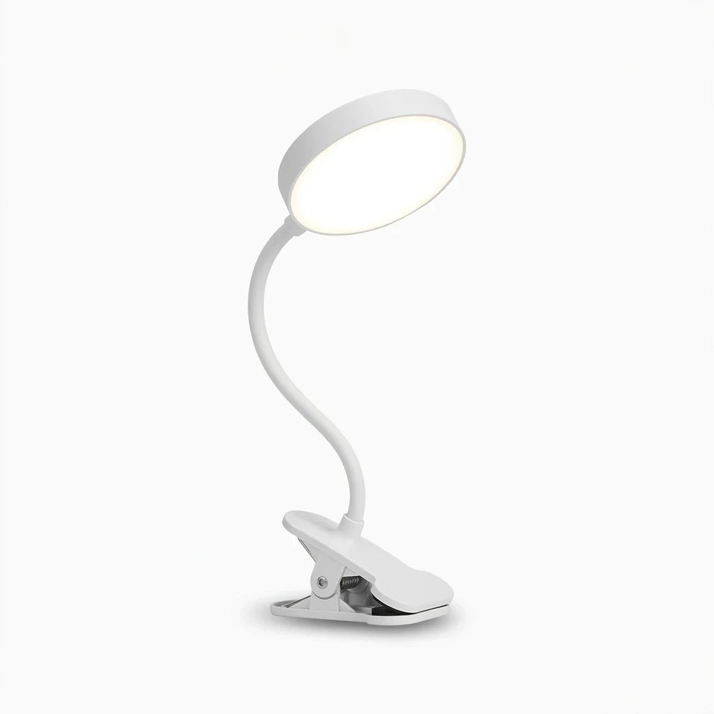 Lampe de chevet à pince noire fixée sur le bord d'une table de nuit, diffusant une lumière chaude