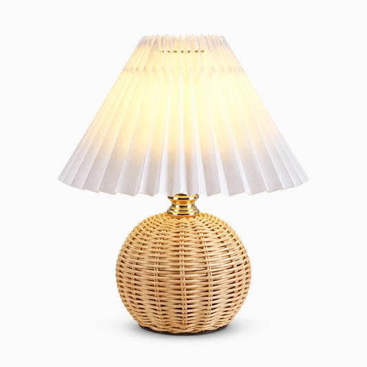 Lampe de chevet rétro avec base en rotin et abat-jour plissé crème sur table de nuit