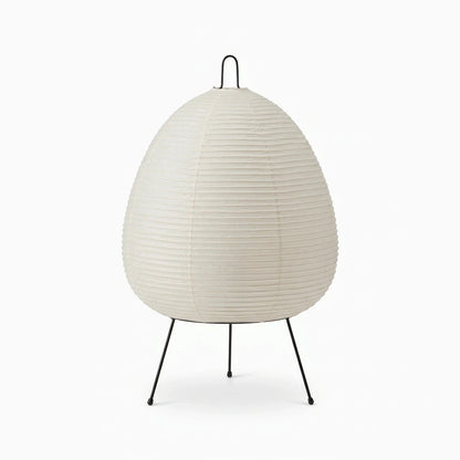 Lampe japonaise en papier avec abat-jour texturé diffusant une lumière douce sur socle stable