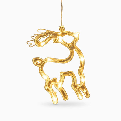 Lampe de noël installée sur un rebord de fenêtre illuminant la nuit avec motifs de renne et Père Noël