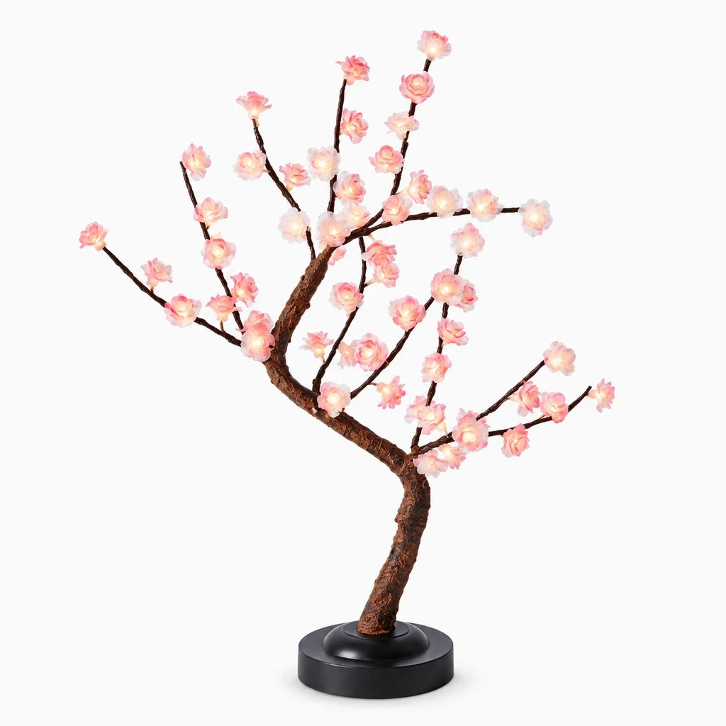 Lampe palmier avec base amovible diffusant une lumière chaude sur une table de jardin