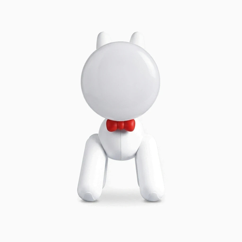 Lampe pour enfant en forme de chiot blanc avec lumière chaude sur une table de nuit