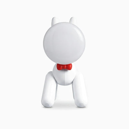 Lampe pour enfant en forme de chiot blanc avec lumière chaude sur une table de nuit