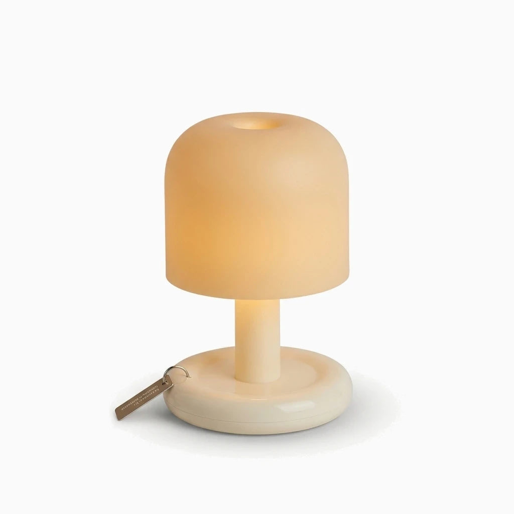 Petite lampe à poser compacte avec dégradé de lumière chaude sur table de chevet