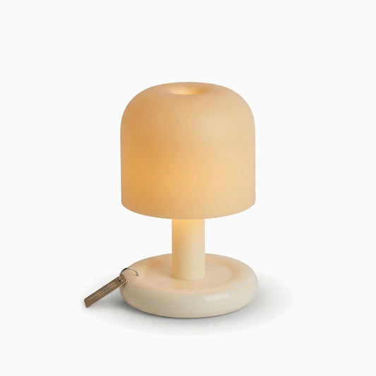 Petite lampe à poser compacte avec dégradé de lumière chaude sur table de chevet