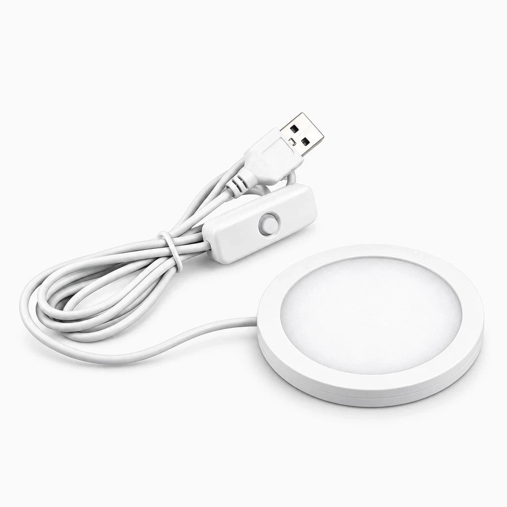 Veilleuse compacte posée sur table de nuit, diffusant une lumière douce blanc chaud pour la nuit