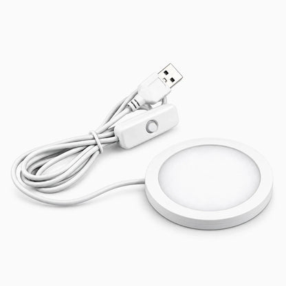 Veilleuse compacte posée sur table de nuit, diffusant une lumière douce blanc chaud pour la nuit
