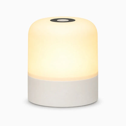 Veilleuse rechargeable tactile émettant une lumière blanche douce sur une table de chevet